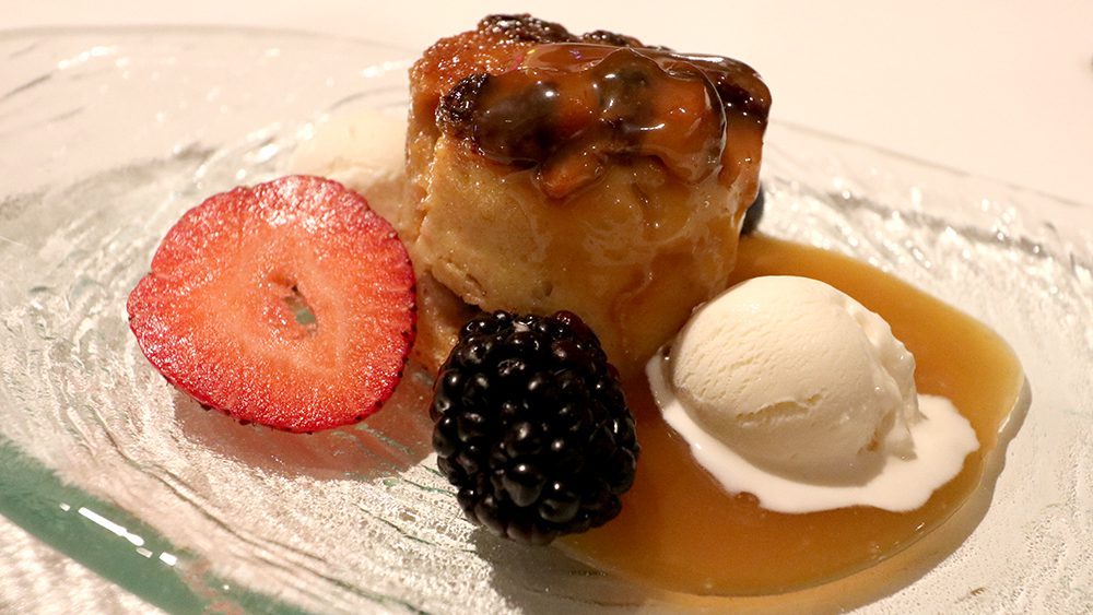 Budin, a Puerto Rican food that's essentially bread pudding with raisins, Bacardi rum, fresh berries, and vanilla ice cream