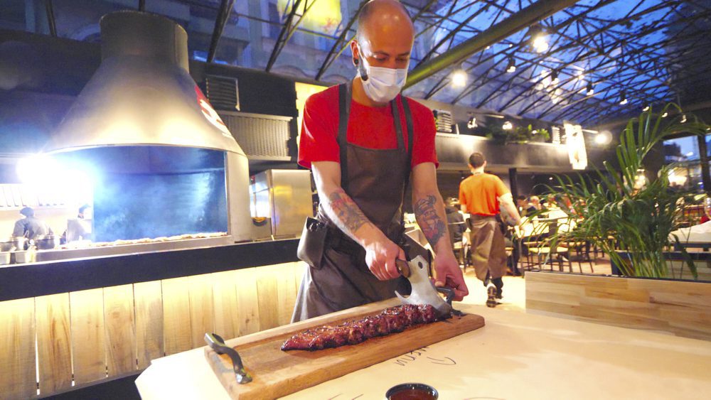 Waiter chopping ribs with an axe at Rebernia Restaurant