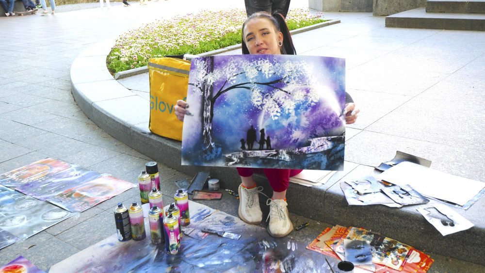 An artist showing off her work on Prymorskyi Boulevard.