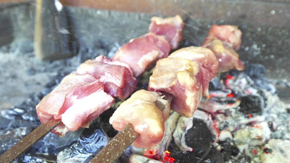 Pork kebabs cooking over coals in Mtskheta, Georgia