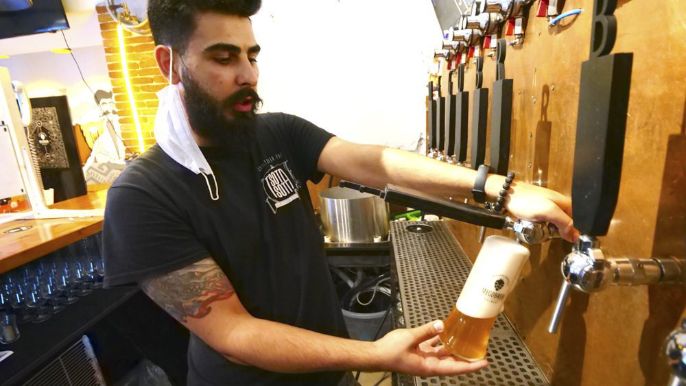 A bartender pouring a beer at Tsota Tsota Craft Beer Pub