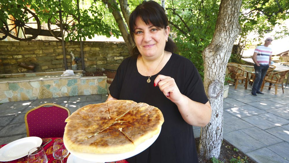 A local woman serving khachapuri at her home near Tbilisi, Georgia