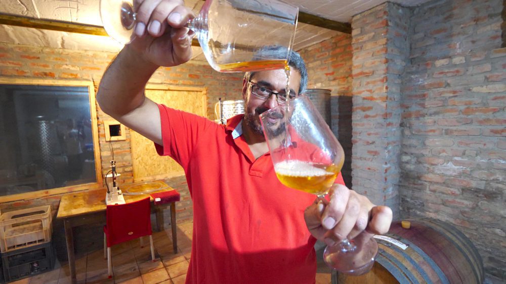 The owner of Wine Artisans pouring wine