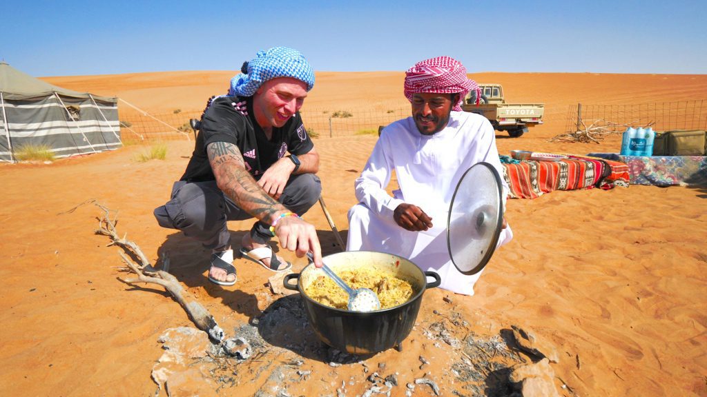 Preparing an Omani Bedouin food called kabsa, made up of rice, boiled chicken, onion, tomatoes, garlic, potatoes, lemon, and spices.