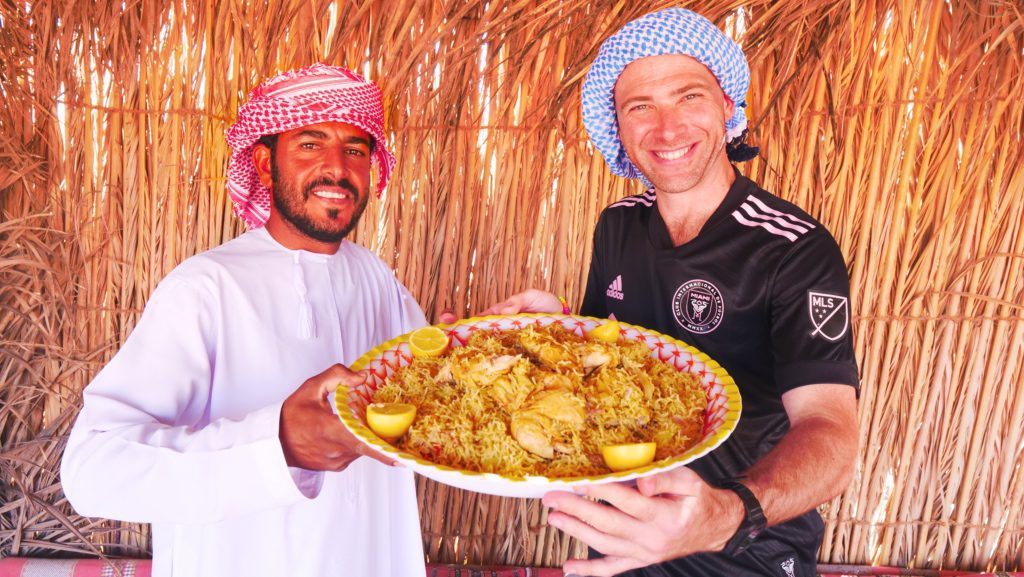 Holding a platter of Kabsa with my Bedouin host and guide
