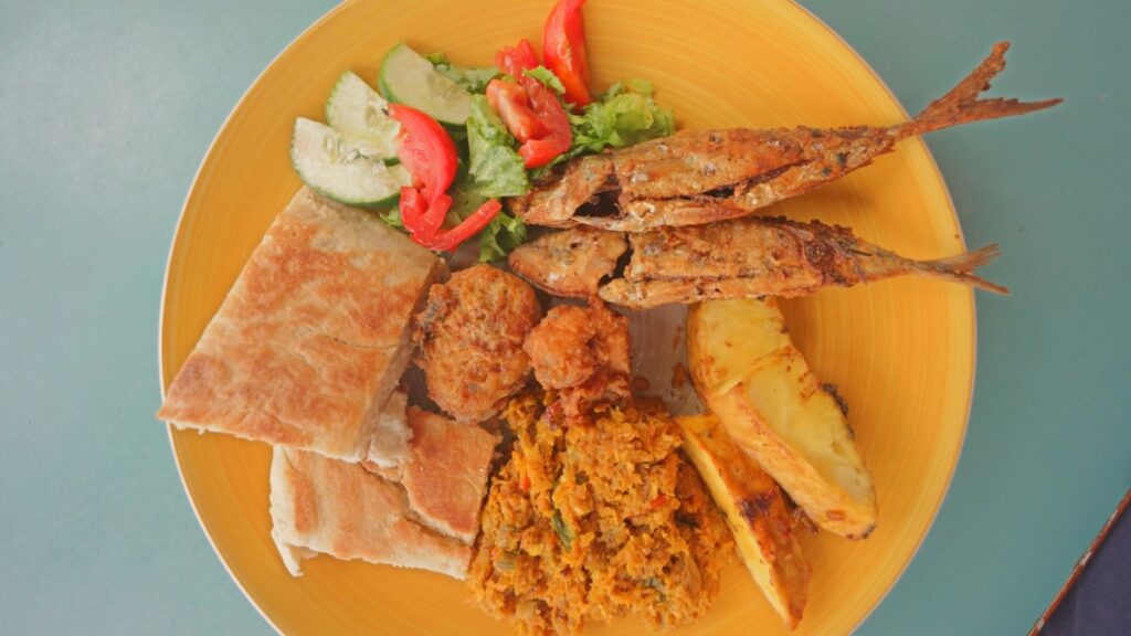 Grenadian fish cakes alongside fried fish, breadfruit, salad, bake, and more | David's Been Here