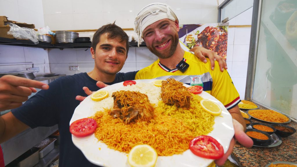 Holding a plate of quzi with my guide Jafar | Davidsbeenhere