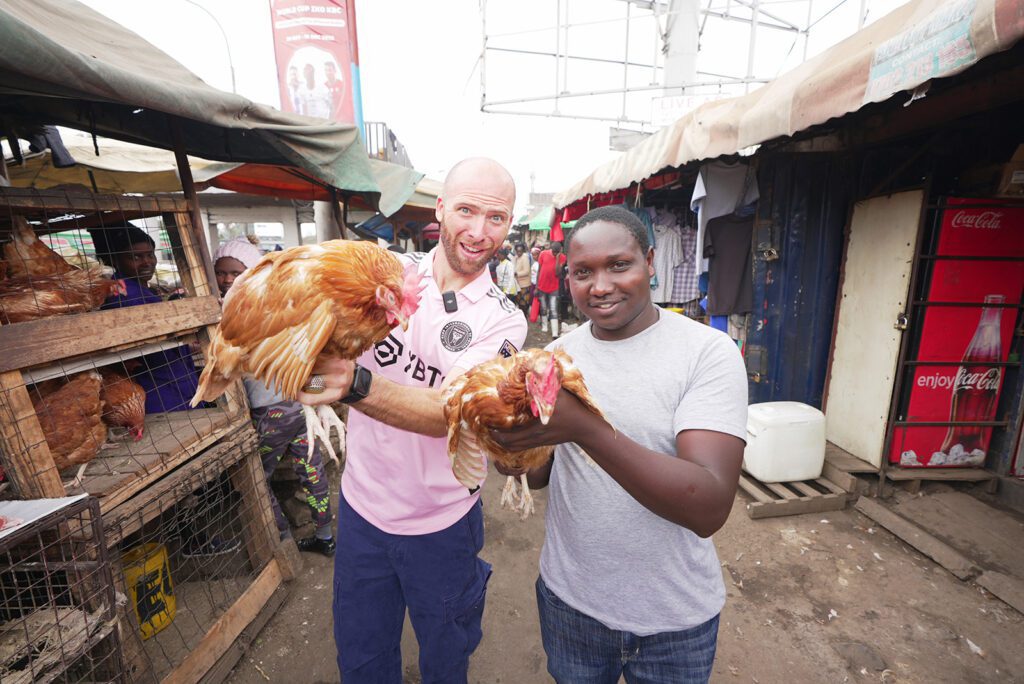 My guide Sam and I holding roosters in a Nairobi market | Davidsbeenhere
