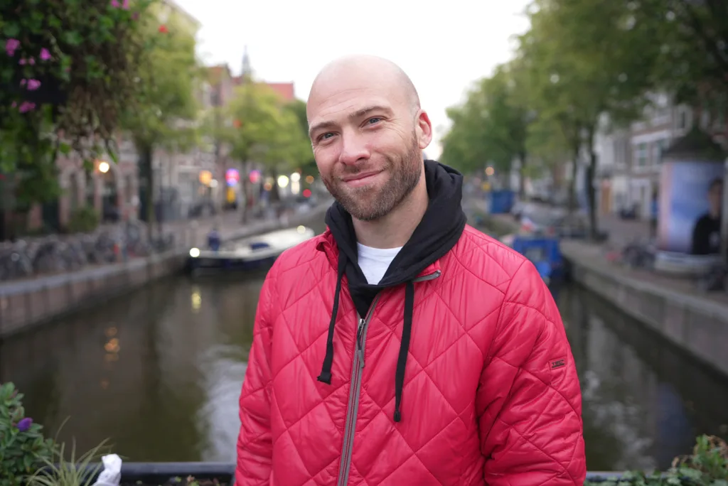 Standing on a bridge overlooking a beautiful canal in Amsterdam, where you should try to learn the Dutch language | Davidsbeenhere 