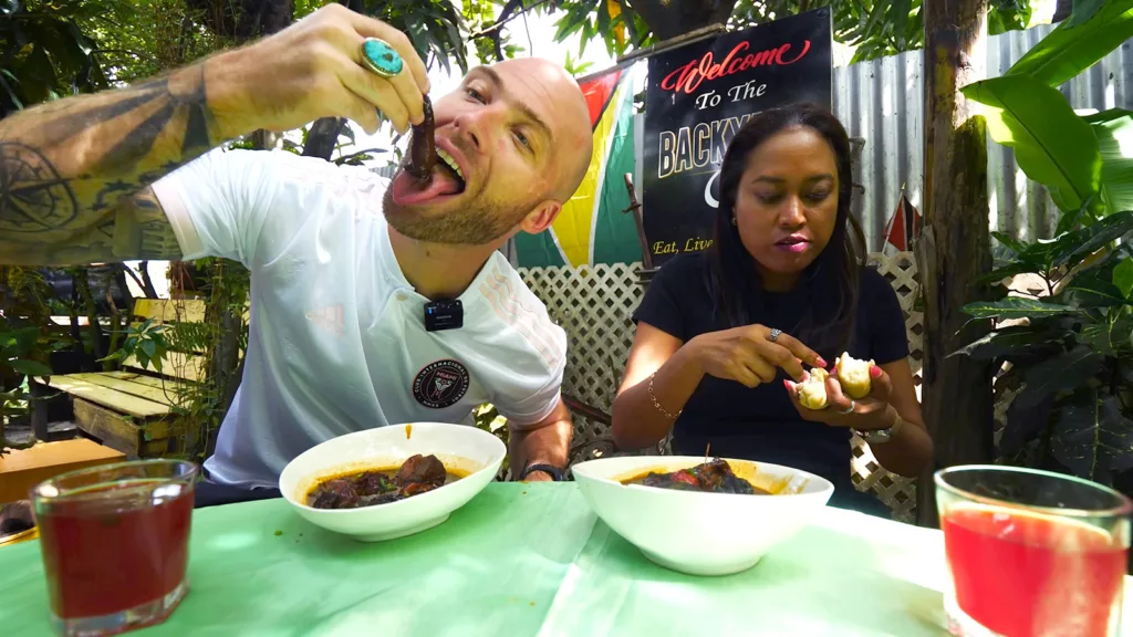 David Hoffmann and his guide Stacey eating fresh pepperpot on the outdoor terrace at The Backyard Café | Davidsbeenhere 