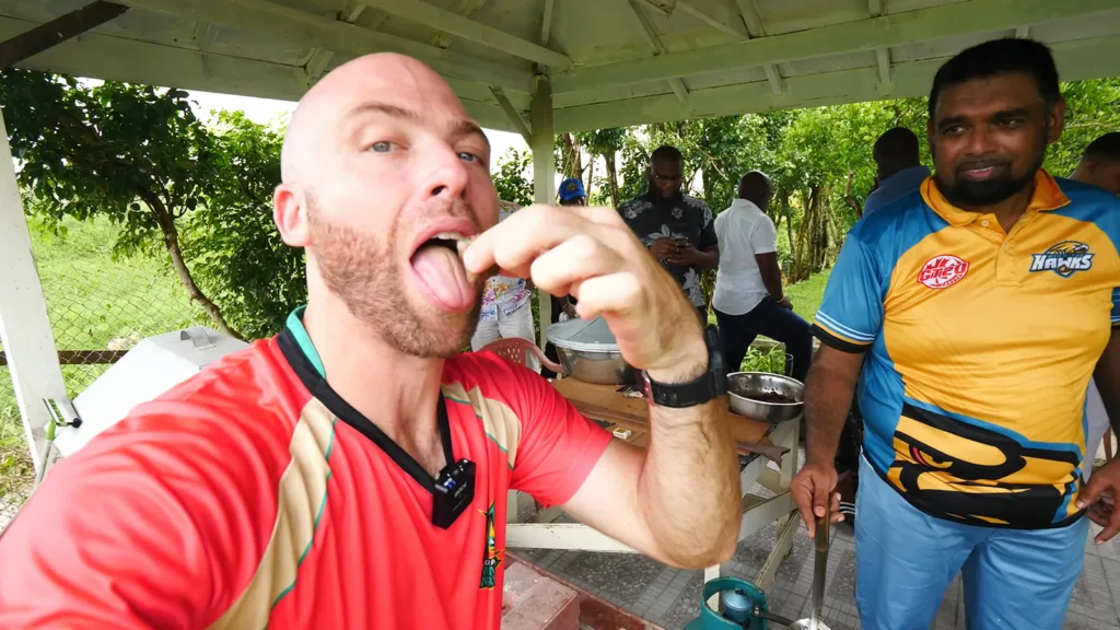 David Hoffmann eats a piece of Guyanese liver fry as the President looks on | Davidsbeenhere