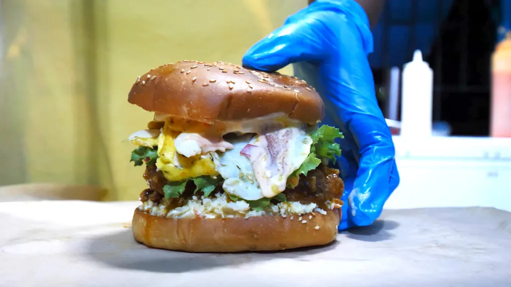 The massive Hawaiian fish burger at King & Queens Bar-B-Que, which comes topped with onions, turkey bacon, caramelized onions, pineapple, a fried egg, and more | Davidsbeenhere