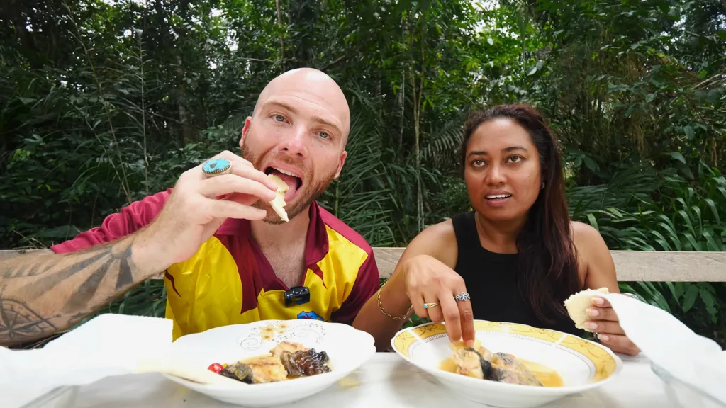 David Hoffmann and his guide Stacy eating bowls of tuma, a popular Indigenous food, and cassava bread in the jungles of Guyana | Davidsbeenhere