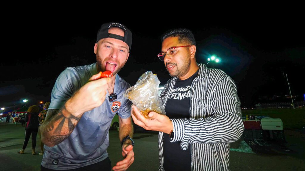 David Hoffmann and Chef Jason Peru enjoy a bag of pineapple, watermelon, prune, and mango chow in Port of Spain, Trinidad | Davidsbeenhere