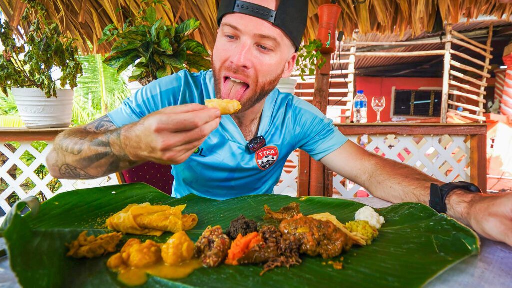 David Hoffmann takes a bite of dal puri while eating the best Caribbean food at Aunty Doll's in Trinidad | Davidsbeenhere