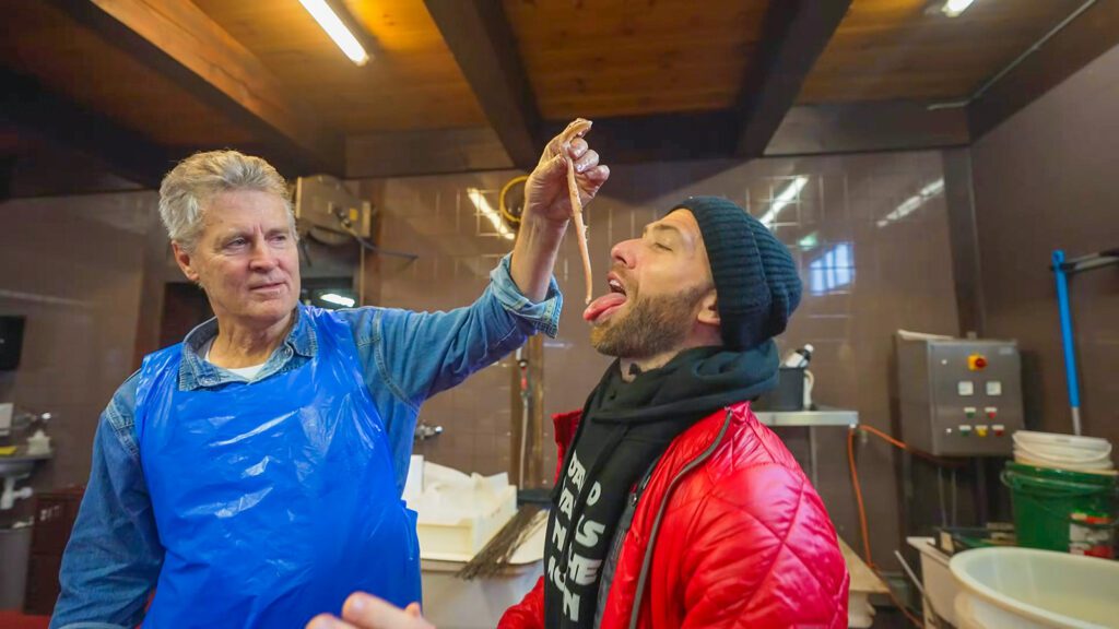 The owner of Smit Bokkum Restaurant feeds David Hoffmann a fresh smoked eel | Davidsbeenhere