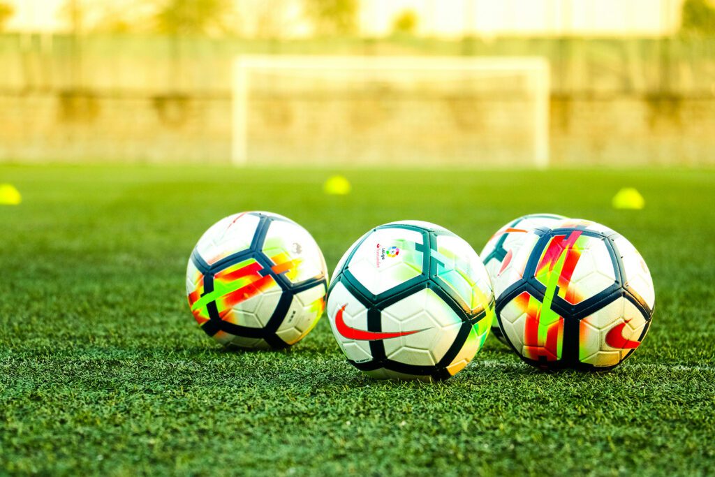 Colorful soccer balls on a football pitch | Davidsbeenhere