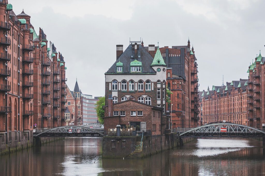Historic buildings and homes lining a waterway spanned by bridges in Speicherstadt | Davidsbeenhere