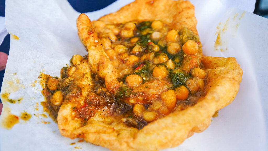 Doubles, one of the ultimate Caribbean dishes, consists of two fried flatbreads topped with chickpea curry and chutneys | Davidsbeenhere