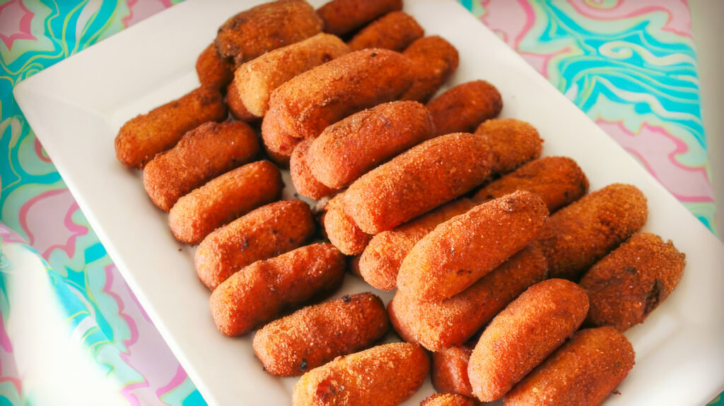 A plate loaded with croquetas stacked on top of one another | Davidsbeenhere