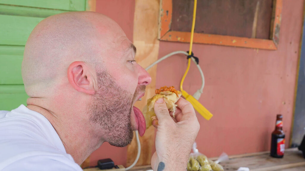 David Hoffmann enjoys a large bite of buss-up shut and curry on the island of Grenada, home to many of his favorite Caribbean dishes | Davidsbeenhere