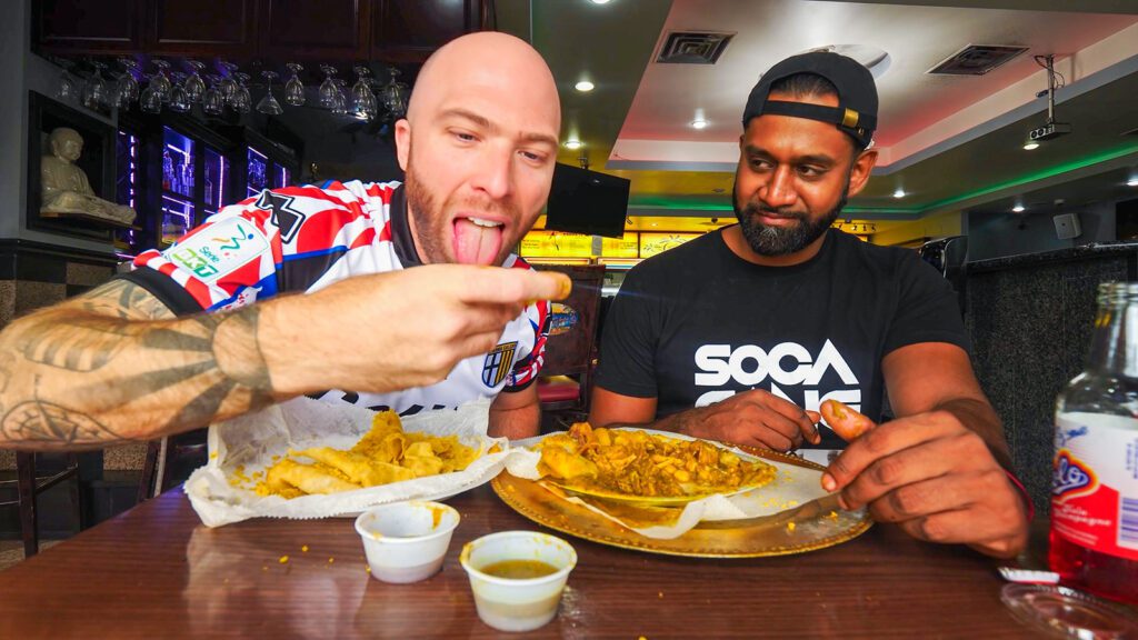 DJ Jon Jat looks on as David Hoffmann eats dal puri with shrimp curry and oxtails at Singh's | Davidsbeenhere