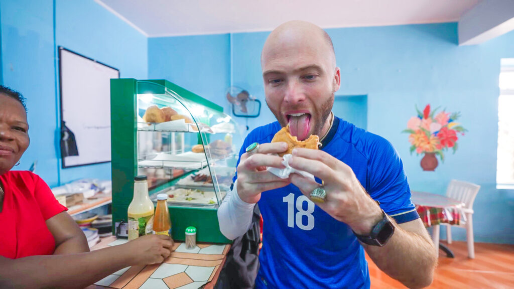 David Hoffmann takes a big bite of a saltfish bake as part of his Dominican breakfast in Portsmouth, Dominica | Davidsbeenhere