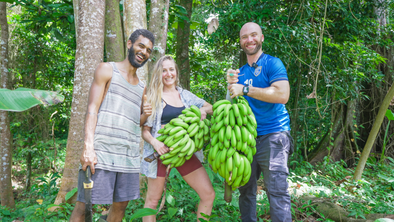 David Hoffmann holds a bundle of bananas with the owners of Free-Up Farms in Dominica | Davidsbeenhere