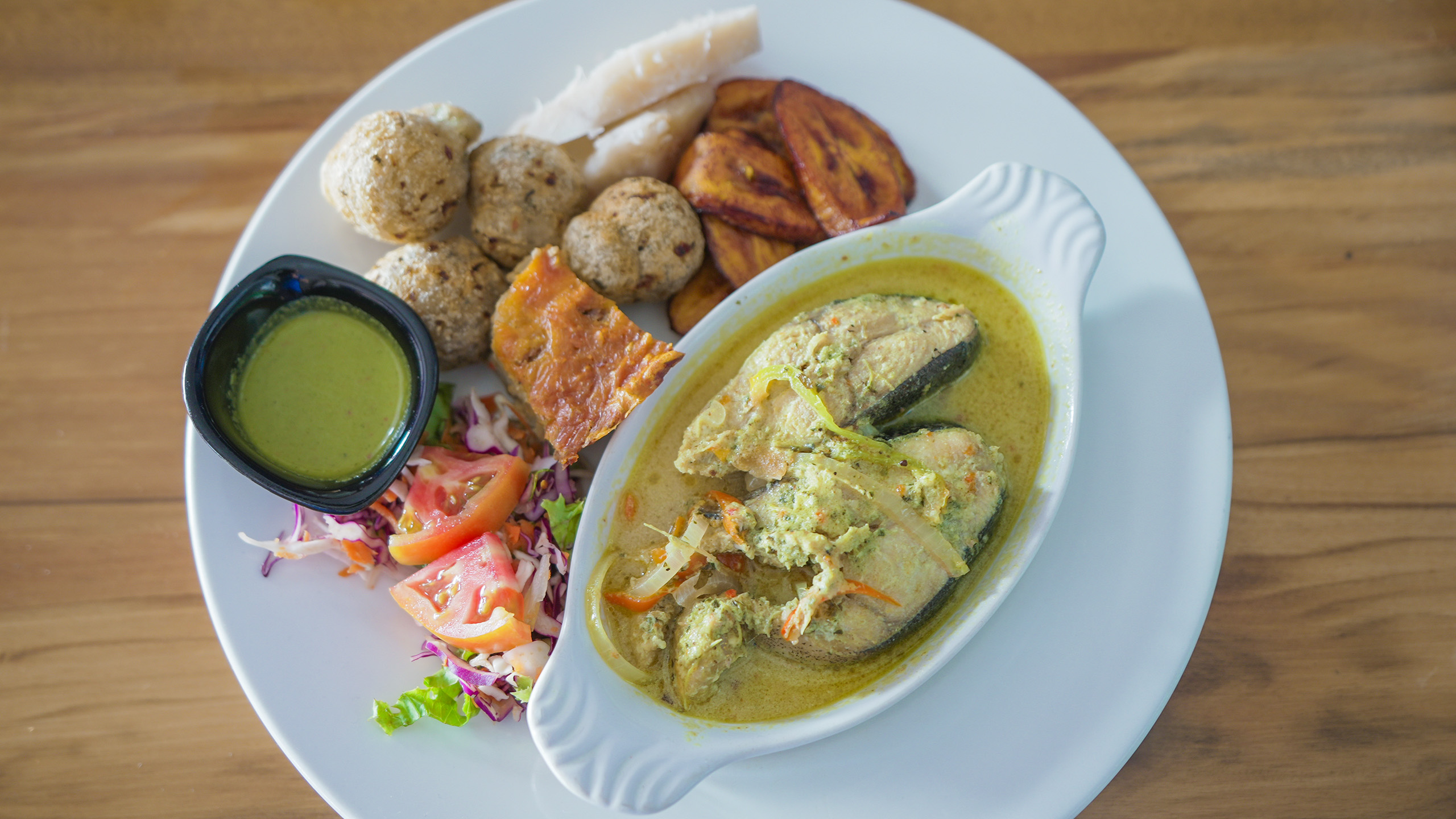 Mahi mahi curry, fried plantains, fried taro balls, and salad in Dominica | Davidsbeenhere