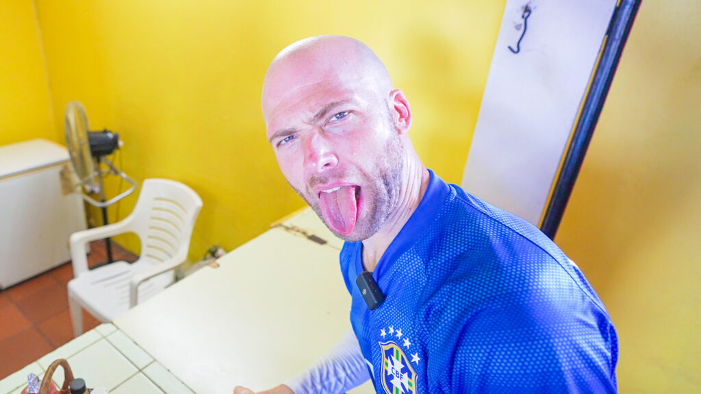 David Hoffmann sticks out his tongue in reaction to the spicy saltfish bake he tried in Roseau, Dominica | Davidsbeenhere